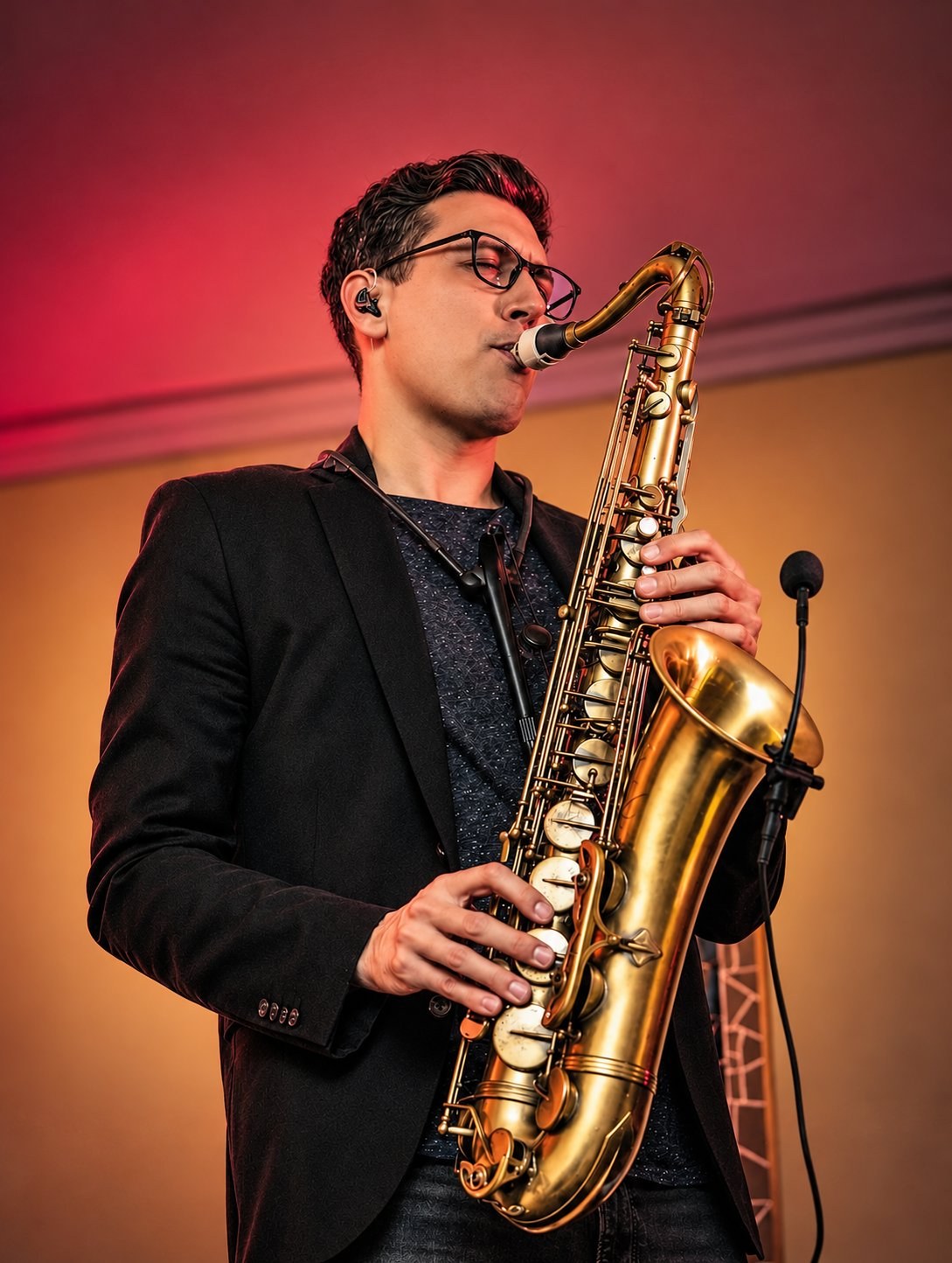 Saxophonist im Sakko bei warmem Licht